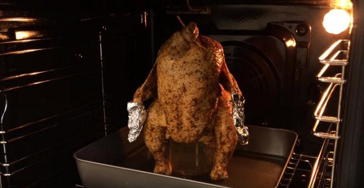 Umístěte plech na pečení s kuřetem na drátěný stojan, připraví se asi hodinu.