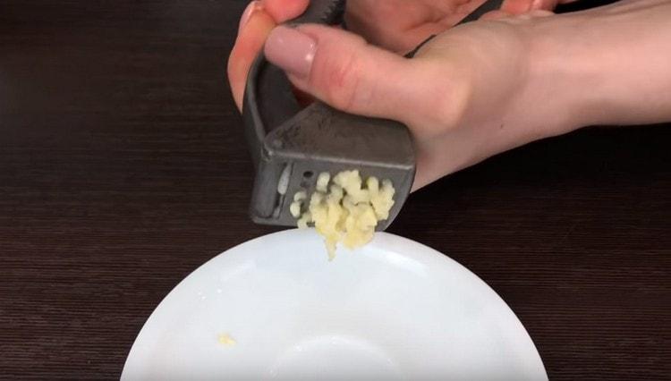 Passare l'aglio sbucciato attraverso una pressa.