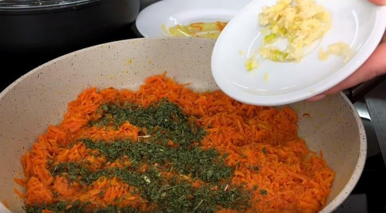Į morkas įpilkite česnako, taip pat pipirų ir džiovintų žolelių.