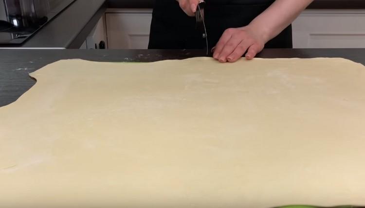 Нарежете навитото тесто на половина.