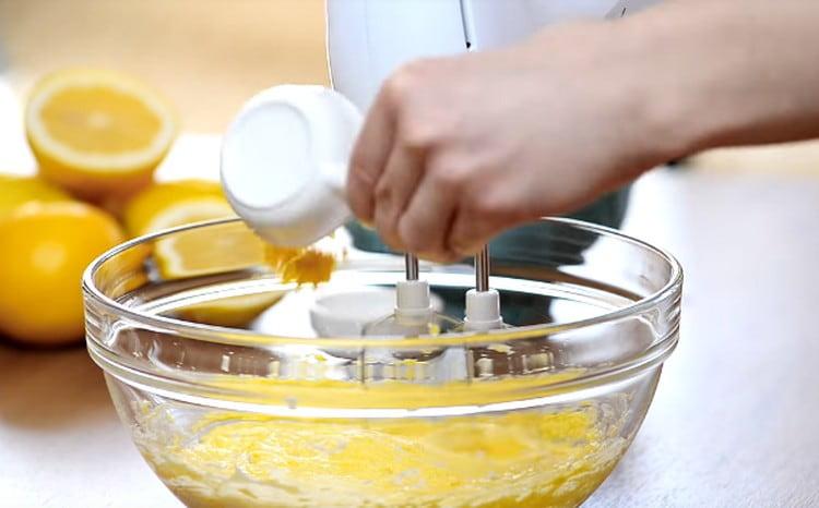 Fügen Sie dem Teig Salz und Zitronenschale hinzu, ohne mit dem Schlagen aufzuhören.