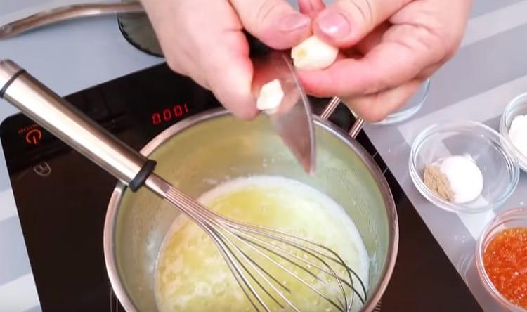 Нарежете скилидка чесън на кремообразна маса.