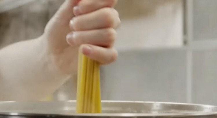 Добавете сол във врящата вода и разпределете спагетите.