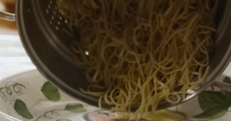 След като кипнем спагетите до готвене, го сгъваме в гевгир и след това го прехвърляме в тиган или дълбока чиния.