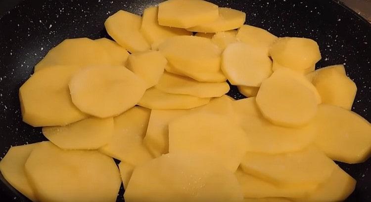 Legen Sie die geschnittenen Kartoffeln in die Pfanne.