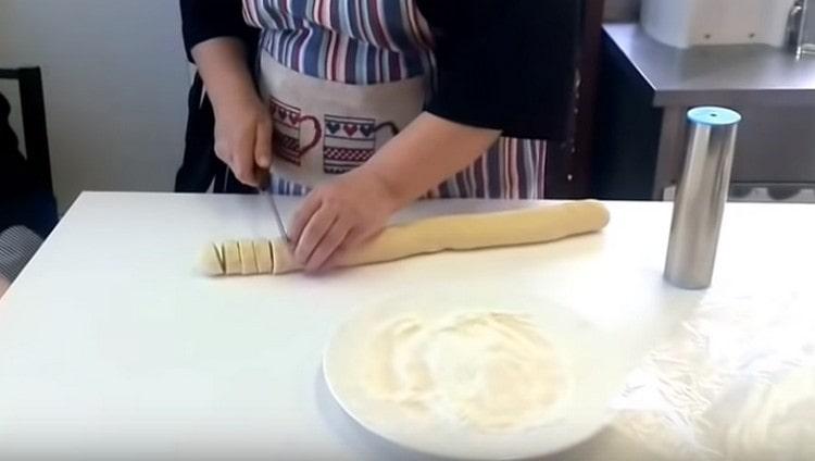 Нарежете наденицата от тестото на порционирани заготовки.