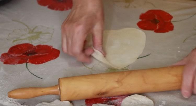 Tekerje a tésztát egy kolbássá, darabokra vágja és mindegyiket gördítéssel csavarja be.