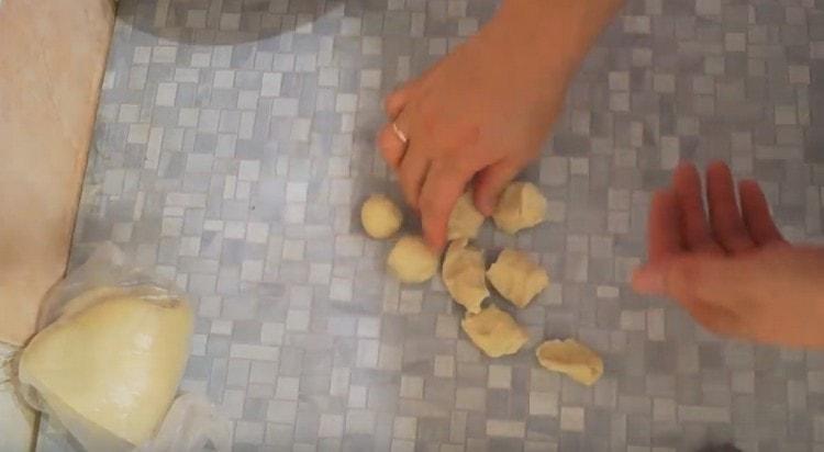 نقطع نقانق العجين إلى قطع ونلفها إلى كرات.