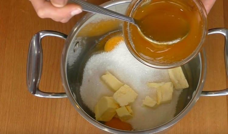 In einem Topf kombinieren wir Butter, Zucker, Eier und flüssigen Honig.