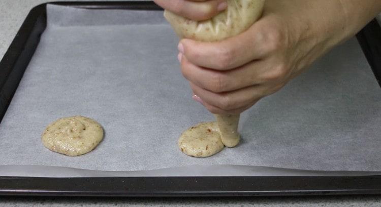 Formiamo dei biscotti rotondi su una teglia coperta di pergamena.