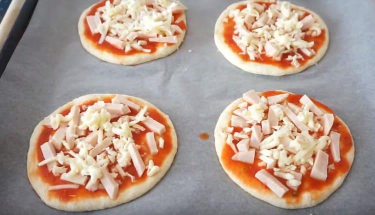 Разстелете шунка и сирене върху всяка мини пица.