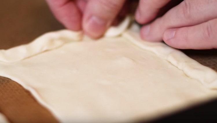 نضع كل فارغة على ورقة الخبز وتشكيل الجانبين.