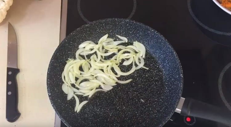 Pane porkkanoiden jälkeen pannulle puoliksi renkaiksi leikattu sipuli.