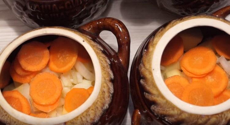 Προσθέστε κρεμμύδια με καρότα πάνω από τις πατάτες.