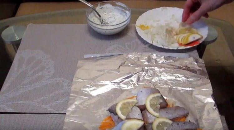 Mettiamo le fette di pesce sulle verdure, mettiamo il limone su ognuna di esse.