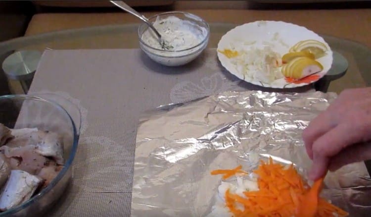 Разпределяме върху фолиото част от лук и моркови.