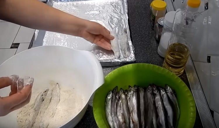 Оваляйте всяка риба в брашно и разпределете на редове върху лист за печене.