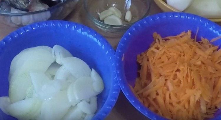 Schneiden Sie die Zwiebel in halbe Ringe, drei Karotten.