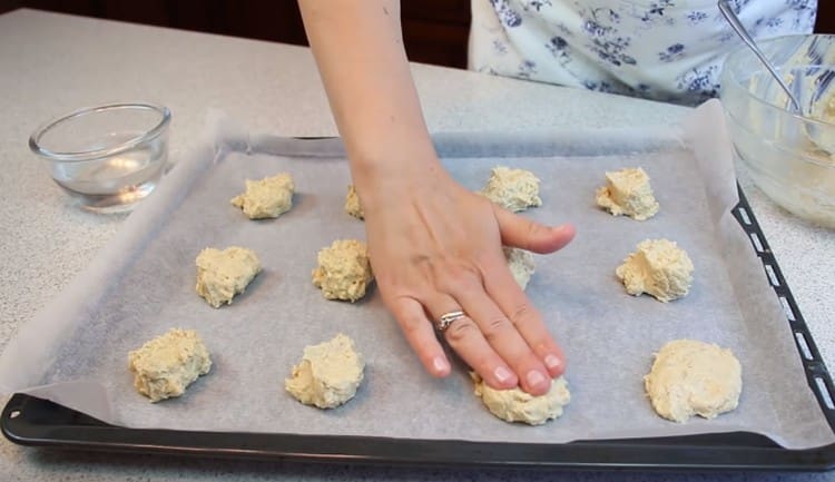 Wir richten Kekse mit den in Wasser angefeuchteten Fingern aus.
