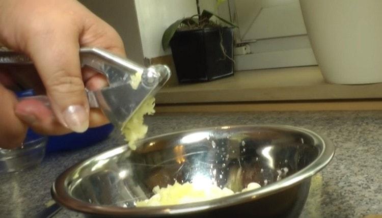 Πιέστε το σκόρδο στην ξινή κρέμα με ένα πρέσα.