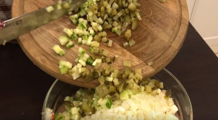 Нарежете пресни и кисели краставици, добавете към салатата.