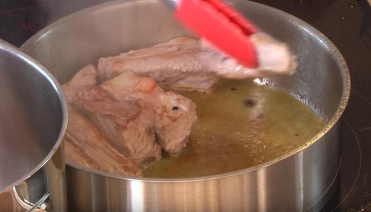 Αφαιρούμε το κοτόπουλο από το τηγάνι και απλώνουμε τις νιφάδες χοιρινού κρέατος για να τηγανίζουμε.