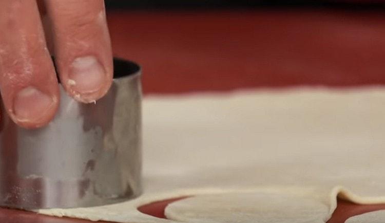 С помощта на формичка изрежете кръгли парчета тесто от тестото.