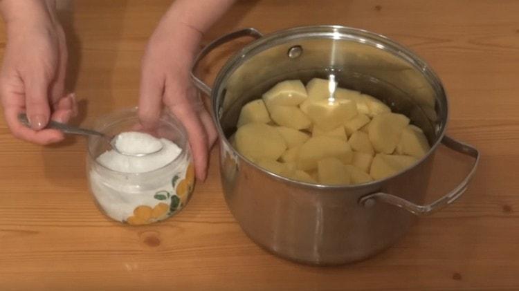 Обелете картофите, нарежете на филийки и поставете да се готвят, като добавите сол.