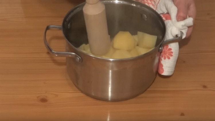 Die fertigen Kartoffeln in einem Kartoffelpüree kneten.
