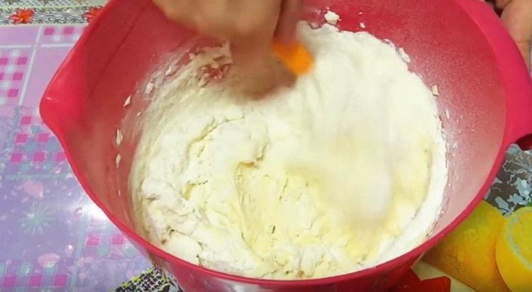 Προσθέστε ένα άλλο μέρος του αλεύρου και ανακατέψτε τη μάζα με ένα κουτάλι.