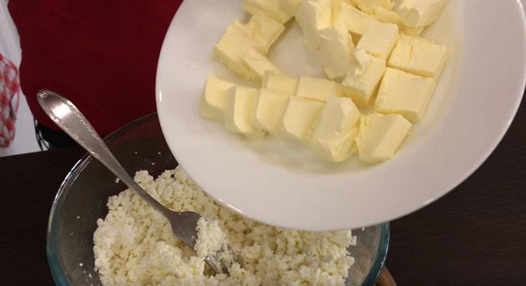 Fügen Sie die gehackte Butter dem Hüttenkäse hinzu.