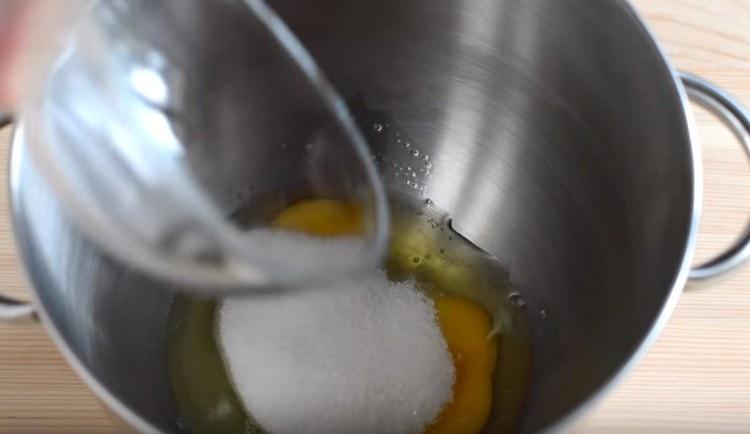 Комбинирайте яйцата със захарта.