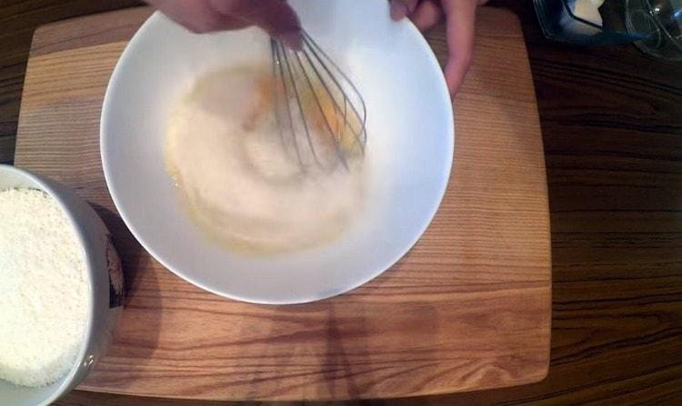 In una ciotola, sbattere le uova, aggiungere lo zucchero e sbattere con una frusta.