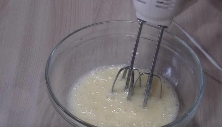 Eier mit einem Mixer mit Zucker schlagen.