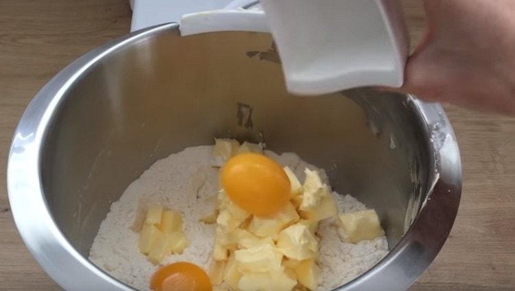 Két tojássárgáját terítsük el a lisztet és a vajat.