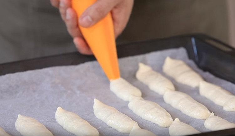 Τοποθετούμε τα cookies με τη μορφή δακτύλων (ή μπαστούνια) σε ένα φύλλο ψησίματος που καλύπτεται με περγαμηνή.