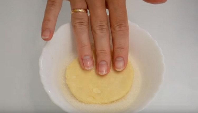 Потопете кръг от тестото в захарта от едната страна.