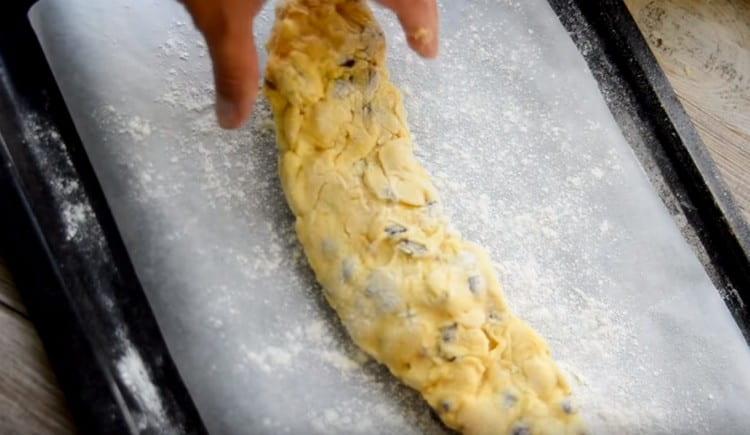 Siirrä tämä makkara varovasti leivinpeitteelle, joka on peitetty pergamentilla ja ripotettu jauhoilla.