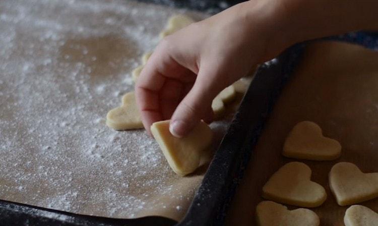 Inilipat namin ang cookies sa isang baking sheet, na natatakpan ng pergamino at binuburan ng harina, at ipinadala sa oven.