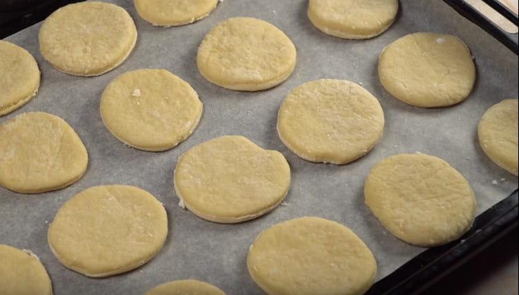 Distribuiamo i futuri biscotti su una teglia coperta di carta da forno.
