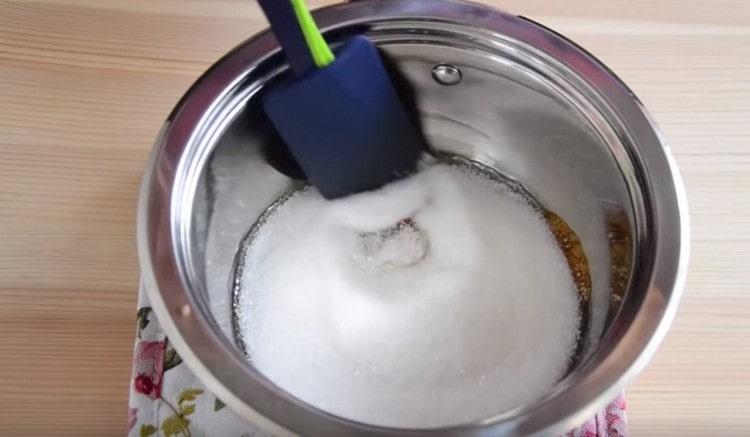 Για να προετοιμάσετε το γέμισμα σε μια κατσαρόλα, λιώστε τη ζάχαρη.
