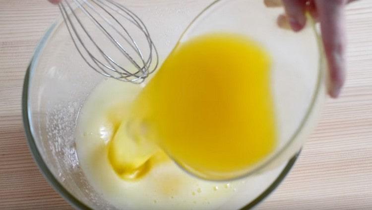 Į kiaušinių masę supilkite išlydytą sviestą.