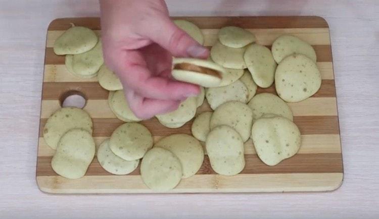 Prendiamo due biscotti, li ungiamo con latte condensato bollito e combiniamo.