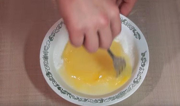 Леко разбийте яйцата със захарта.