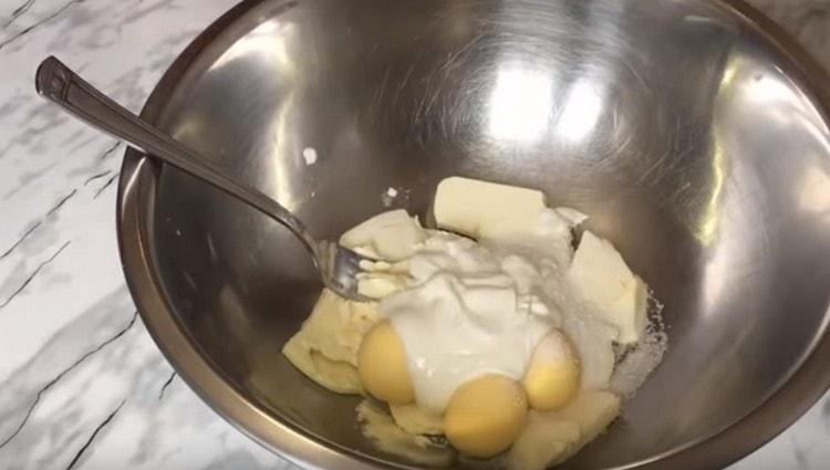 Комбинирайте варени яйчни жълтъци, захар, масло и заквасена сметана в купа.
