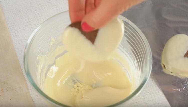 Tauchen Sie jeden Keks in weiße Schokolade.