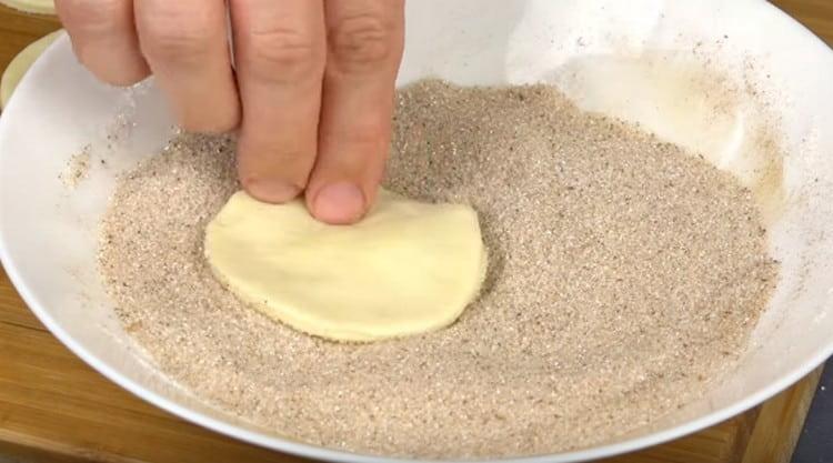 Immergi gli spazi vuoti nella cannella con lo zucchero e forma i biscotti.