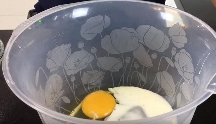 In einer Schüssel die Eier schlagen, Milch hinzufügen.