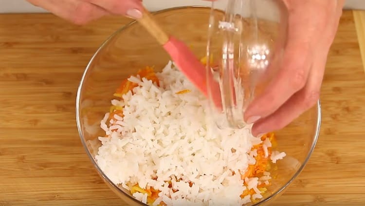 In einer Schüssel kombinieren wir Fisch, Zwiebeln mit Karotten und auch Reis.
