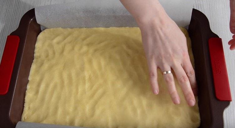 Ρυθμίζουμε τη βάση για την πίτα σε ένα φύλλο ψησίματος.